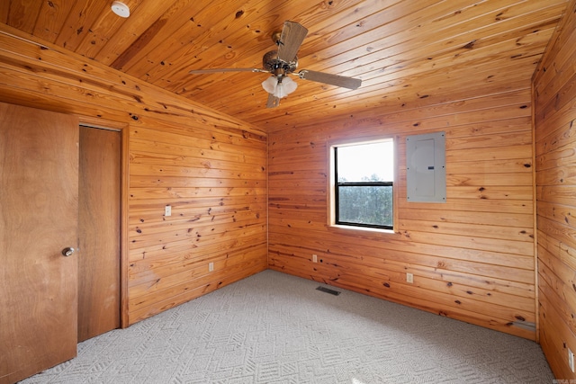 spare room with wood ceiling, light colored carpet, electric panel, and wood walls