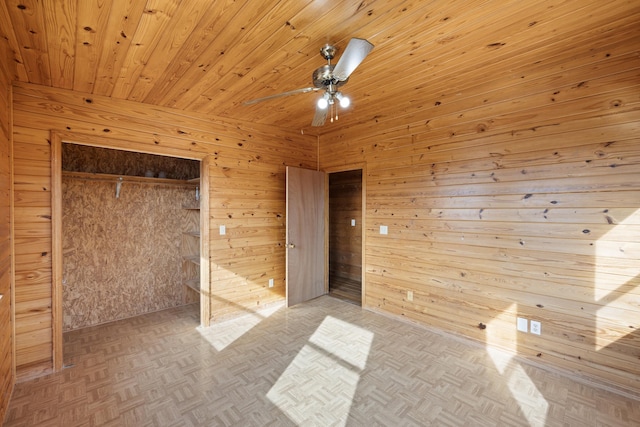 unfurnished bedroom with wood ceiling, parquet flooring, a closet, and wood walls