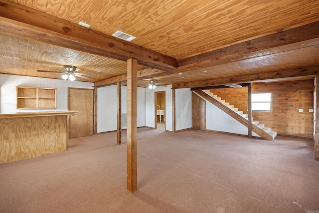 basement with wood ceiling, ceiling fan, wooden walls, and light colored carpet