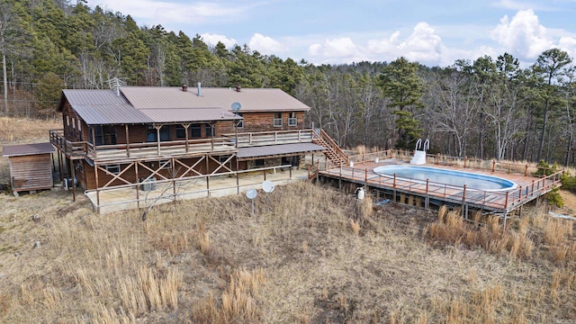 back of house with a pool side deck