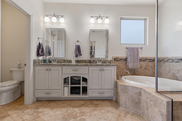 bathroom featuring a relaxing tiled tub, vanity, and toilet