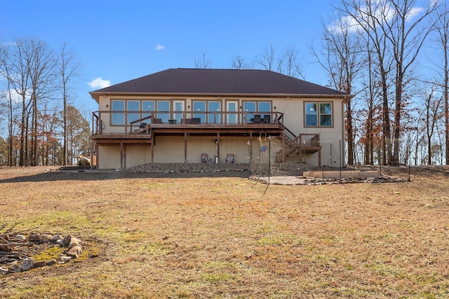 rear view of property with a deck and a lawn