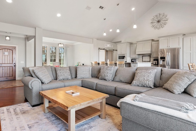 living room with high vaulted ceiling and light hardwood / wood-style flooring