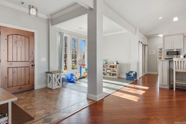 entryway featuring crown molding, wood-type flooring, and a barn door