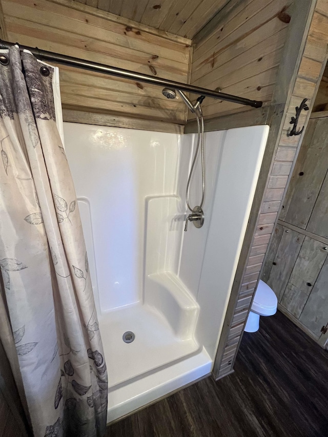 bathroom with wood walls, hardwood / wood-style floors, wooden ceiling, and a shower with shower curtain