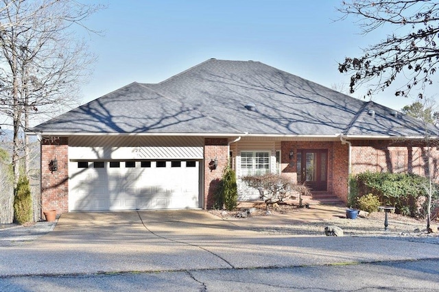 view of front of house with brick siding, driveway, an attached garage, and a shingled roof