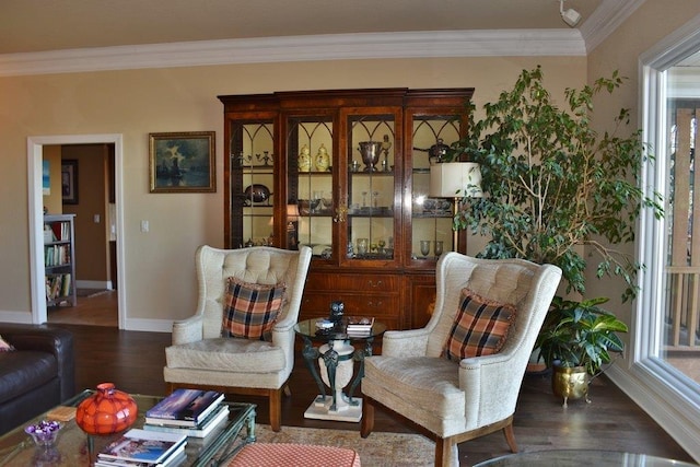 living area featuring a wealth of natural light, baseboards, wood finished floors, and crown molding