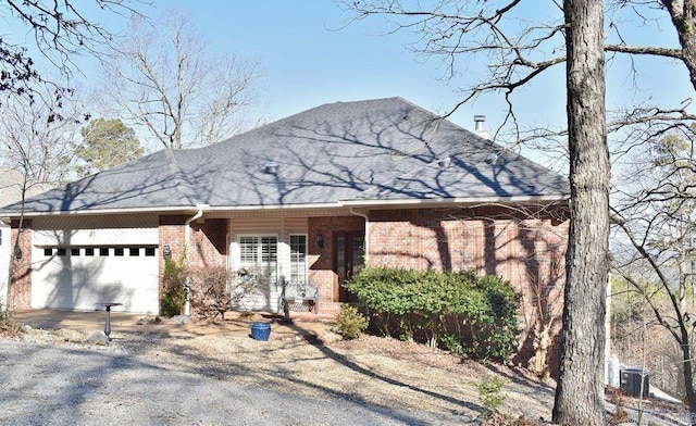 view of front of house featuring brick siding, driveway, an attached garage, and a shingled roof