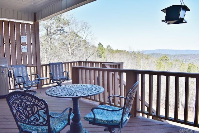 wooden terrace featuring a view of trees