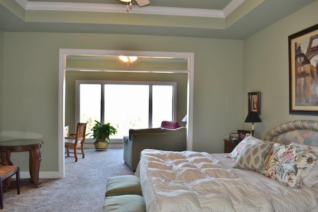 carpeted bedroom featuring baseboards, a raised ceiling, and ornamental molding