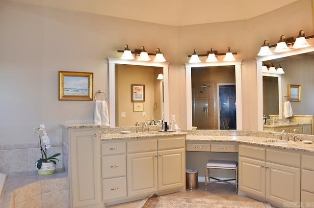 bathroom with a tile shower, two vanities, and a sink