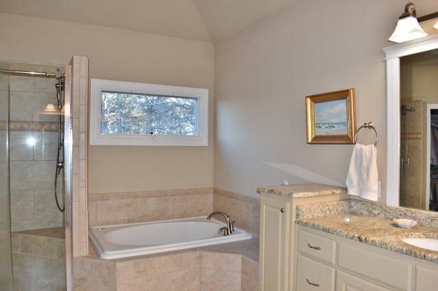 bathroom with vanity, a bath, vaulted ceiling, and a tile shower