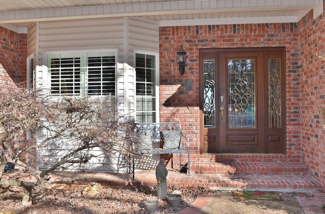 doorway to property featuring brick siding