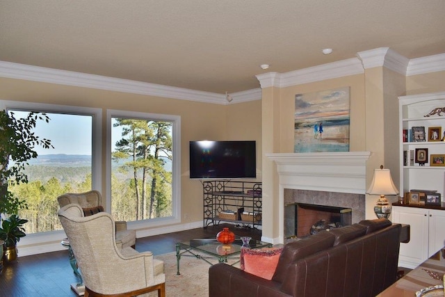 living room with a tiled fireplace, crown molding, and dark hardwood / wood-style floors