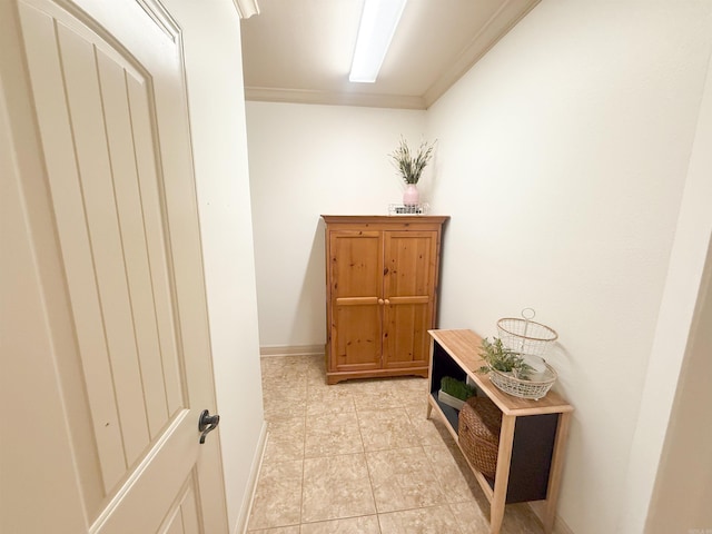 hall featuring light tile patterned floors and crown molding