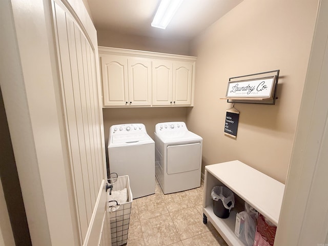 clothes washing area with light tile patterned floors, cabinets, and washing machine and clothes dryer