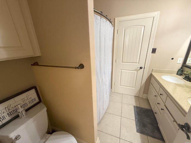 bathroom with tile patterned flooring, vanity, and toilet