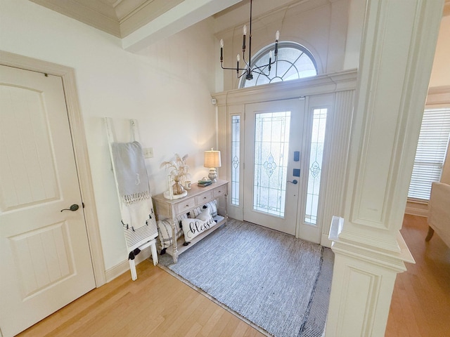 entryway with plenty of natural light, an inviting chandelier, and light hardwood / wood-style flooring