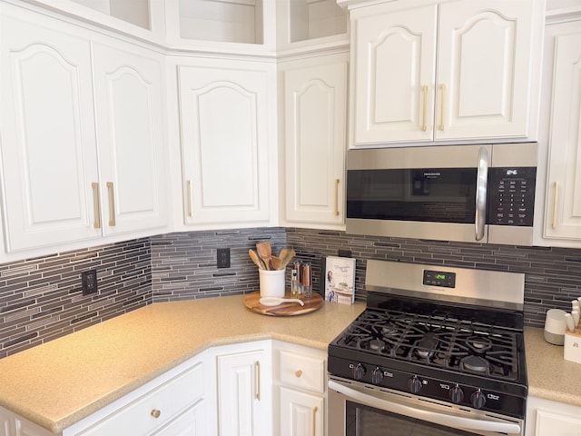 kitchen with white cabinetry, backsplash, and stainless steel appliances