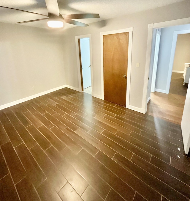 unfurnished bedroom featuring ceiling fan and dark hardwood / wood-style flooring
