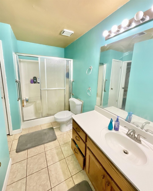 bathroom with vanity, walk in shower, tile patterned floors, and toilet