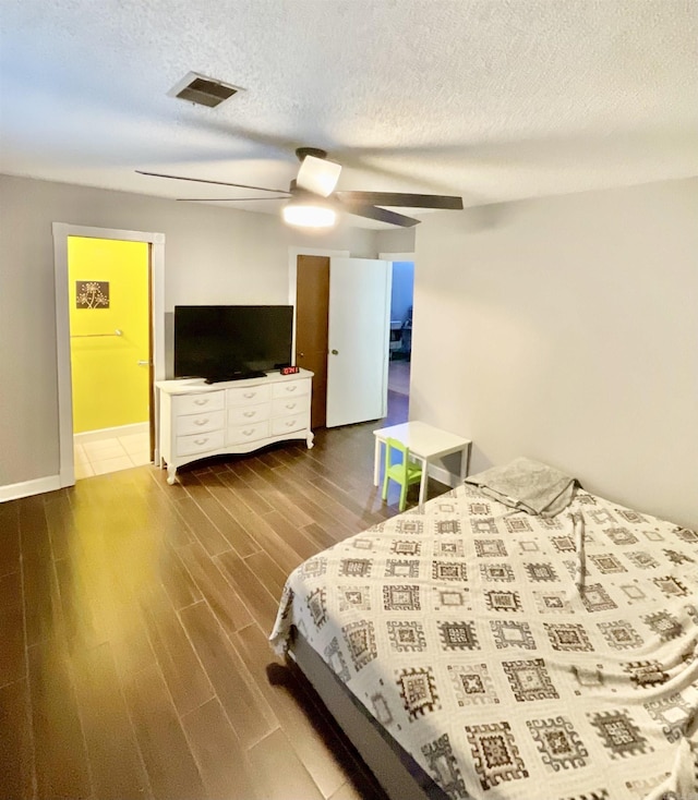 bedroom featuring hardwood / wood-style flooring, ceiling fan, and a textured ceiling