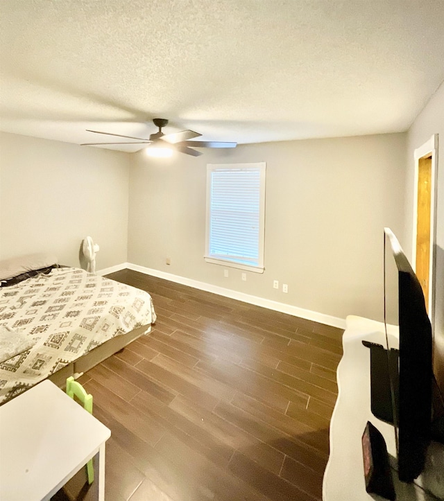 bedroom featuring dark hardwood / wood-style floors, a textured ceiling, and ceiling fan