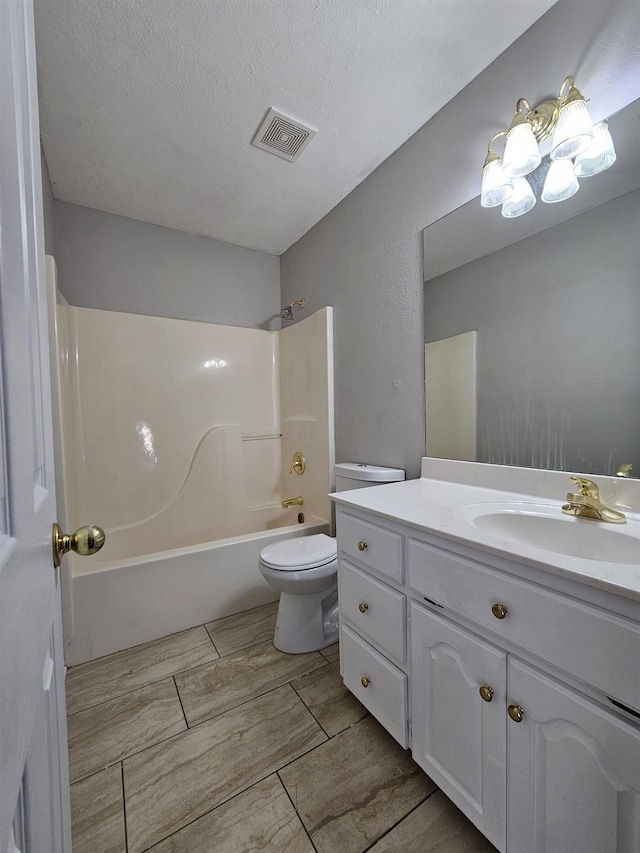 full bathroom with  shower combination, toilet, vanity, and a textured ceiling