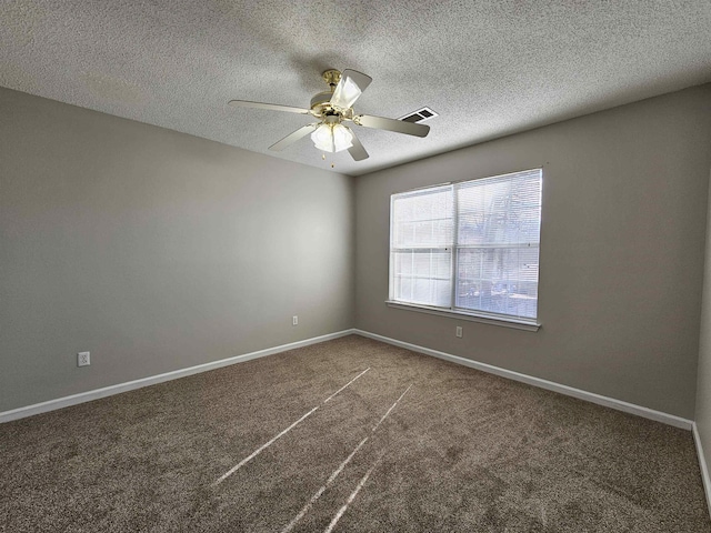 unfurnished room with ceiling fan, a textured ceiling, and dark carpet