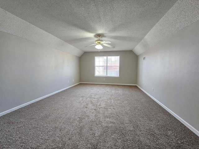 bonus room with ceiling fan, carpet floors, vaulted ceiling, and a textured ceiling