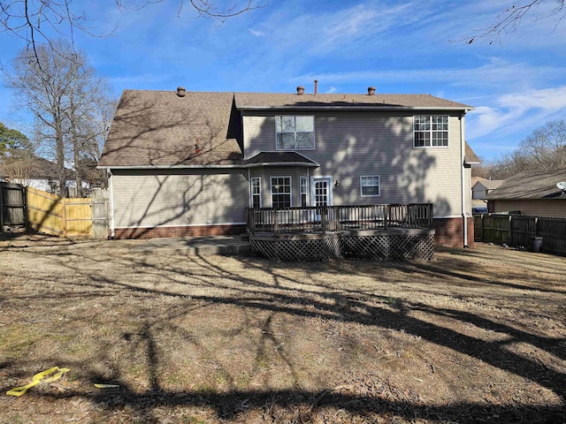 rear view of house featuring a yard and a deck