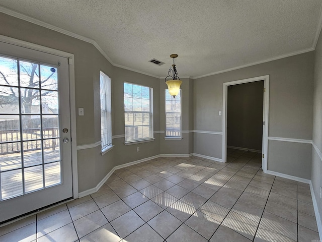 unfurnished dining area featuring ornamental molding, a textured ceiling, and light tile patterned floors