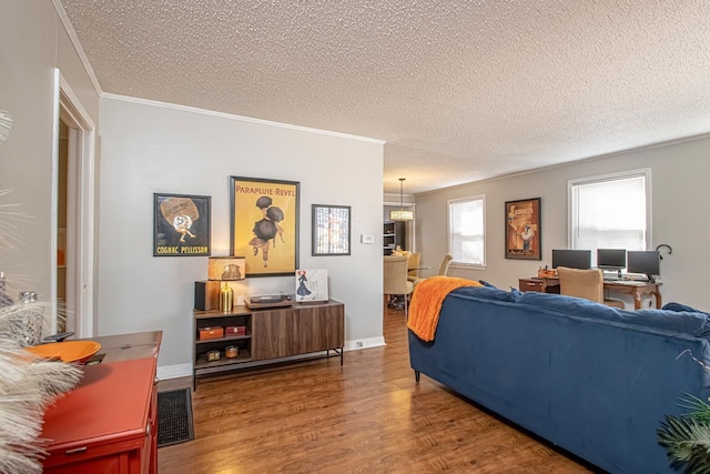 living room with crown molding, wood-type flooring, and a textured ceiling