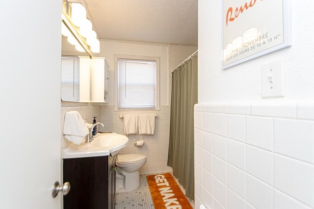 bathroom featuring tile walls, tile patterned flooring, vanity, toilet, and a textured ceiling