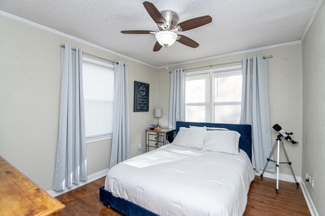 bedroom featuring ornamental molding, dark hardwood / wood-style floors, a textured ceiling, and ceiling fan