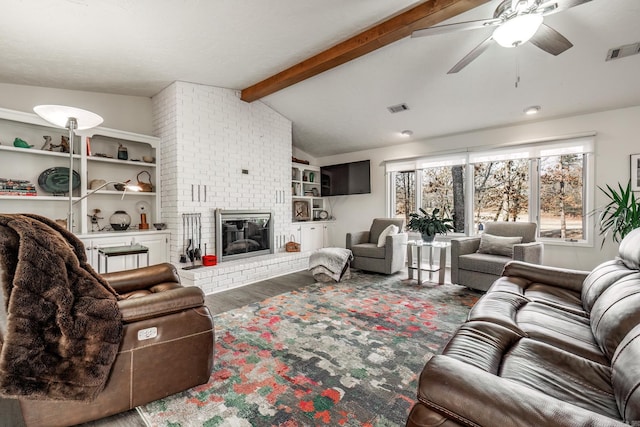 living room featuring ceiling fan, vaulted ceiling with beams, dark wood-type flooring, and a fireplace