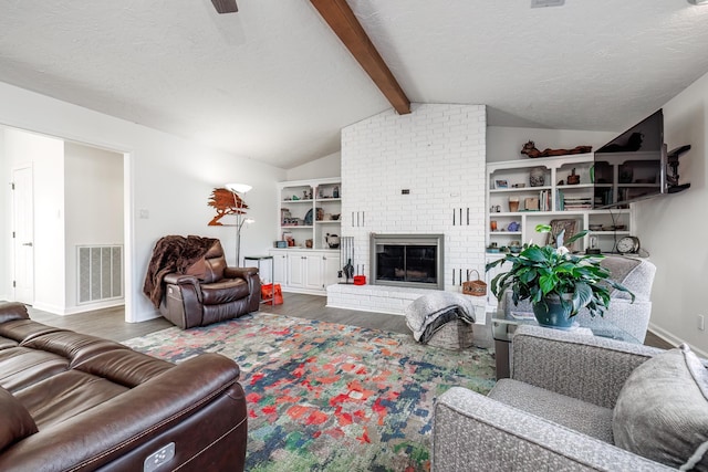 living room featuring hardwood / wood-style floors, a textured ceiling, lofted ceiling with beams, and a brick fireplace