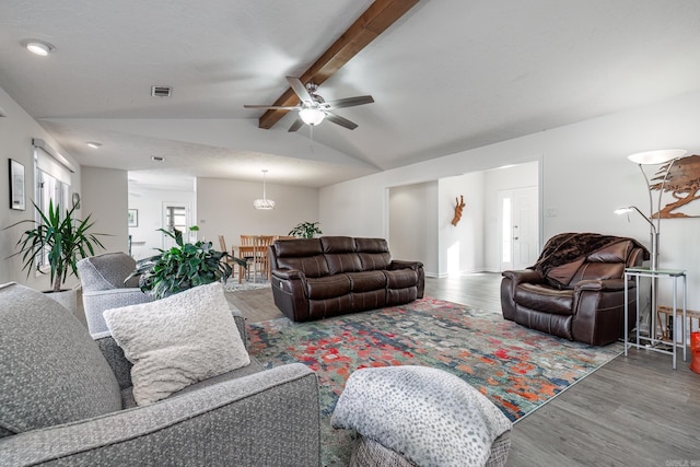 living room with ceiling fan, hardwood / wood-style floors, and vaulted ceiling with beams