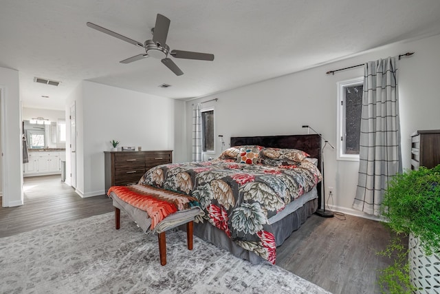 bedroom with connected bathroom, hardwood / wood-style floors, and ceiling fan