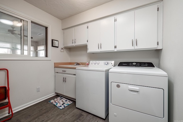 laundry room featuring sink, cabinets, dark hardwood / wood-style floors, washer and dryer, and a textured ceiling