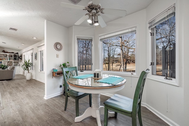 dining room with hardwood / wood-style flooring, ceiling fan, lofted ceiling, and a textured ceiling