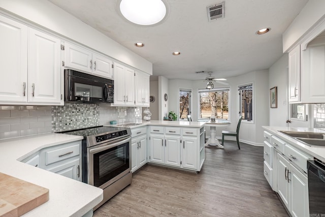 kitchen with black appliances, white cabinetry, sink, decorative backsplash, and kitchen peninsula