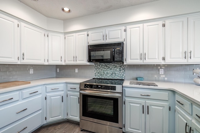 kitchen featuring decorative backsplash, white cabinets, and electric stove