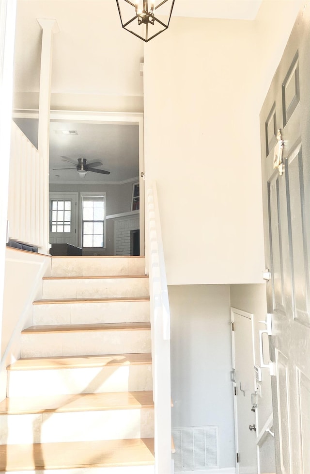 stairway featuring ceiling fan