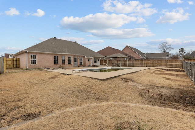 back of house with a yard, a fenced in pool, and a patio area