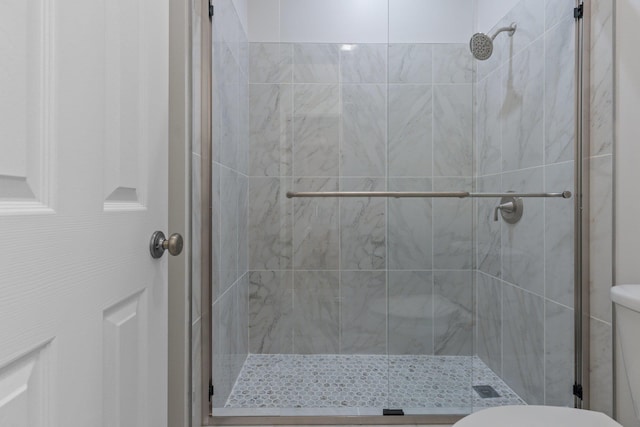 bathroom featuring walk in shower and toilet