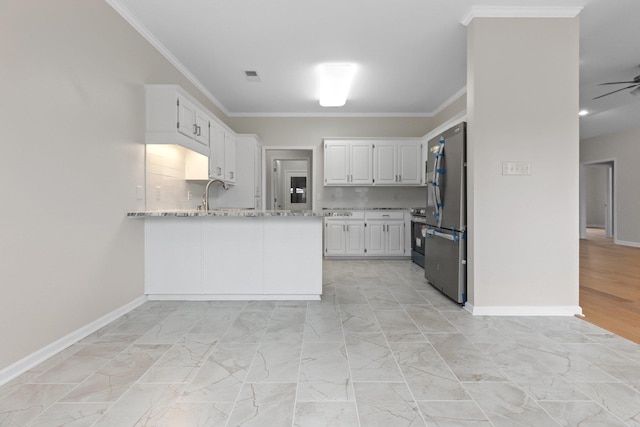 kitchen with white cabinetry, ornamental molding, appliances with stainless steel finishes, kitchen peninsula, and light stone countertops