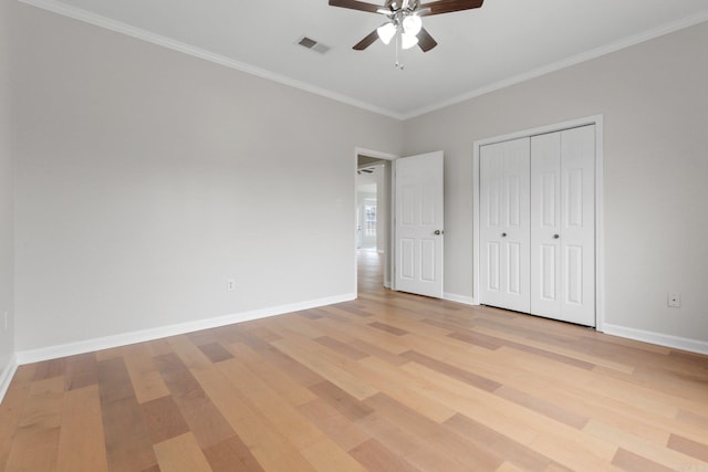 unfurnished bedroom featuring ceiling fan, ornamental molding, a closet, and light wood-type flooring