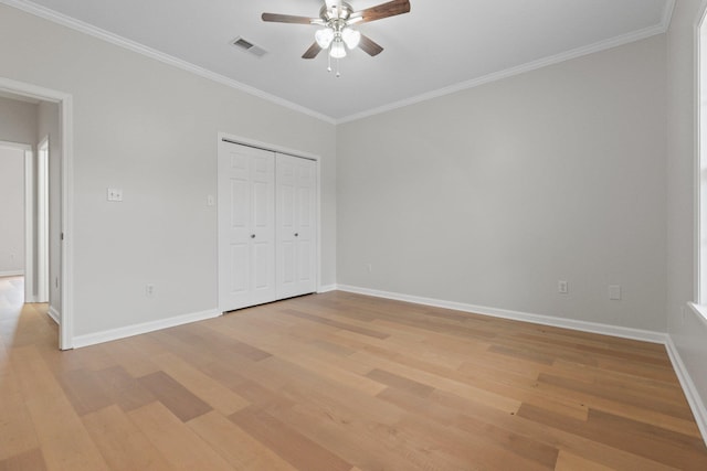 unfurnished bedroom featuring ornamental molding, a closet, ceiling fan, and light hardwood / wood-style flooring