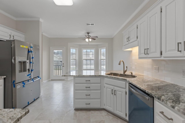 kitchen with appliances with stainless steel finishes, sink, white cabinets, and kitchen peninsula